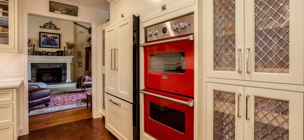 Red double ovens in this white painted kitchen remodel in Cherry Hills