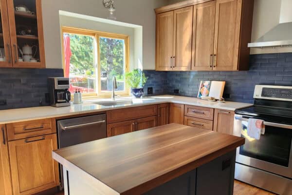 remodeled kitchen from JM Kitchen & Bath Design featuring custom wood finishes and navy blue tile