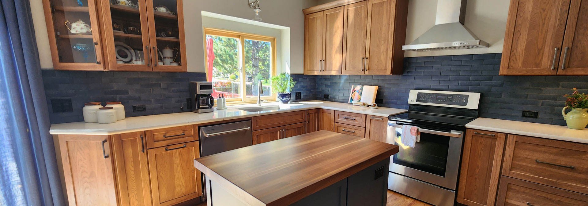 remodeled kitchen from JM Kitchen & Bath Design featuring custom wood finishes and navy blue tile