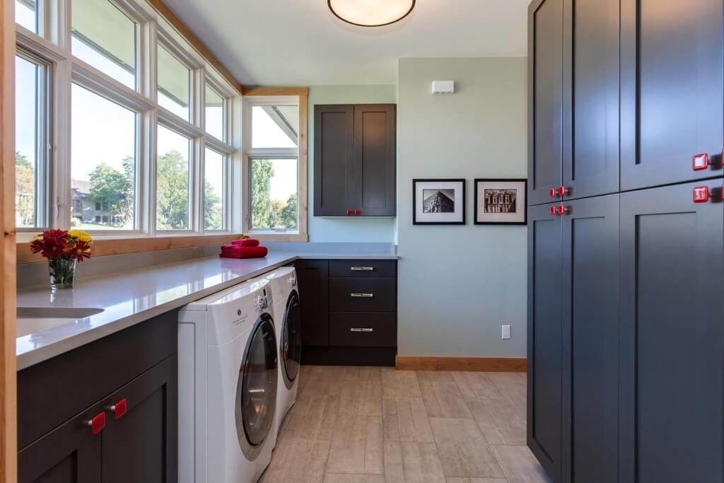 modern laundry room remodel from JM Kitchen & Bath Design featuring plenty of cabinet storage, counter space, and modern appliances