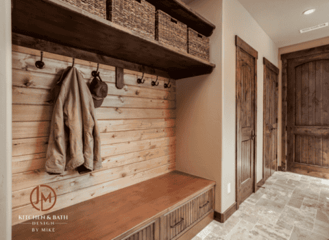 JM Kitchen & Bath Design mudroom remodel with beautiful wood finishes, floor tile, and hooks and baskets for personal items