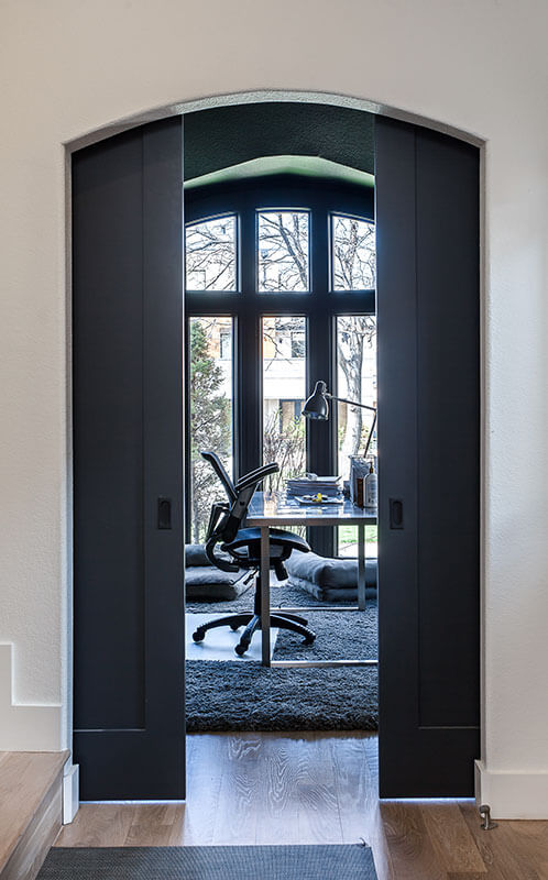 hallway view of sliding gray doors leading into minimalist office JM Kitchen & Bath Design