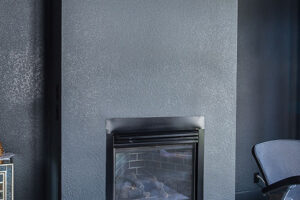 updated fire place surrounded by textured drywall painted gray JM Kitchen & Bath Design