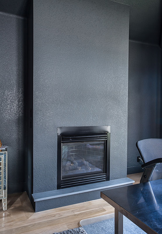 updated fire place surrounded by textured drywall painted gray JM Kitchen & Bath Design