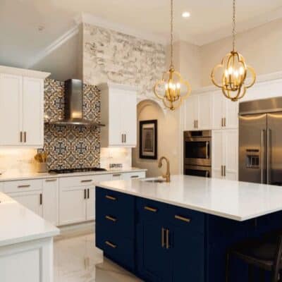 kitchen renovation uses latest trends with dark brass hardware and complimentary tile behind stove JM Kitchen & Bath Design