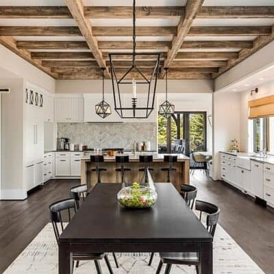 large open concept updated kitchen and dining room area with modern barstools, barn door, and white cabinets JM Kitchen & Bath Design