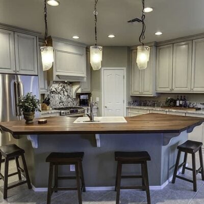 updated kitchen remodel featuring black, gray, and white accents and unique lights above the countertop JM Kitchen & Bath Design