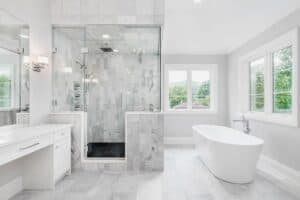 bathroom design remodel includes large tub with white vanity and light gray floors JM Kitchen & Bath Design